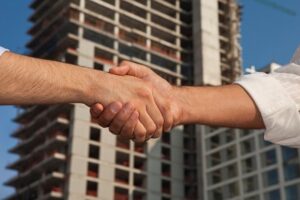 Stock image handshake tall building construction